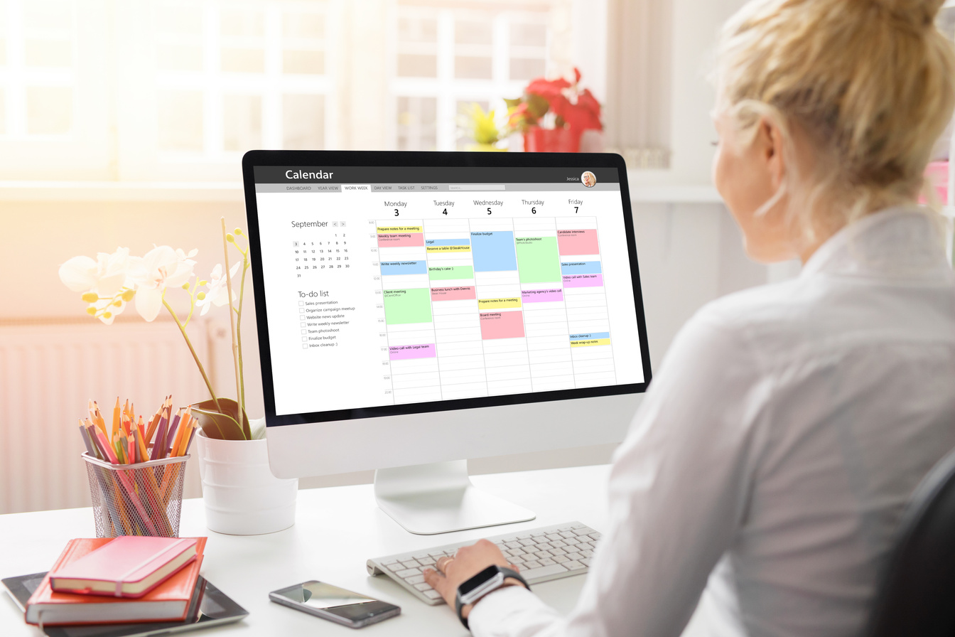Woman Using Calendar on Computer to Organize Work Schedule